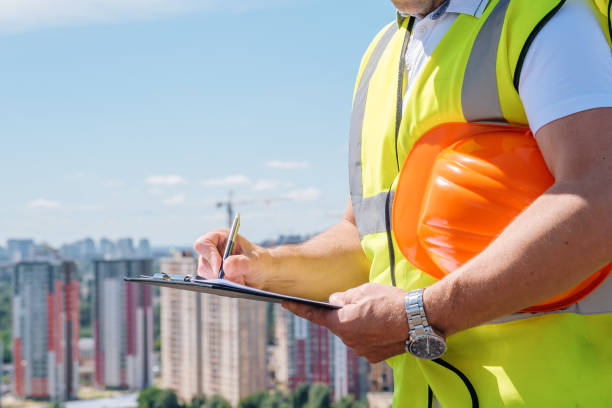 les mains d’un homme mature sur le chantier de construction écrivent des notes sur le presse-papiers en gros plan - suivi de chantier photos et images de collection